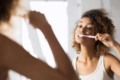 Afro Woman Brushing Teeth In Bathroom, Panorama